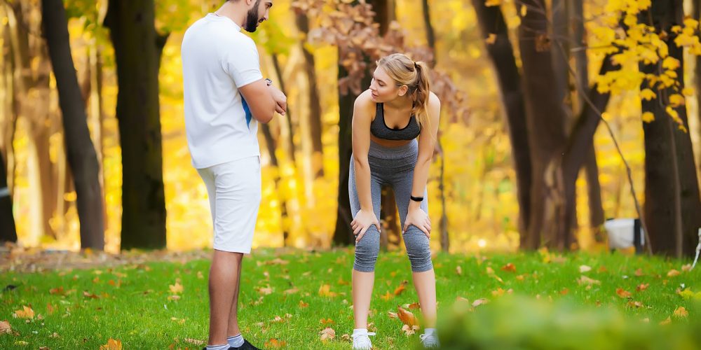 Woman training with personal trainer at park.